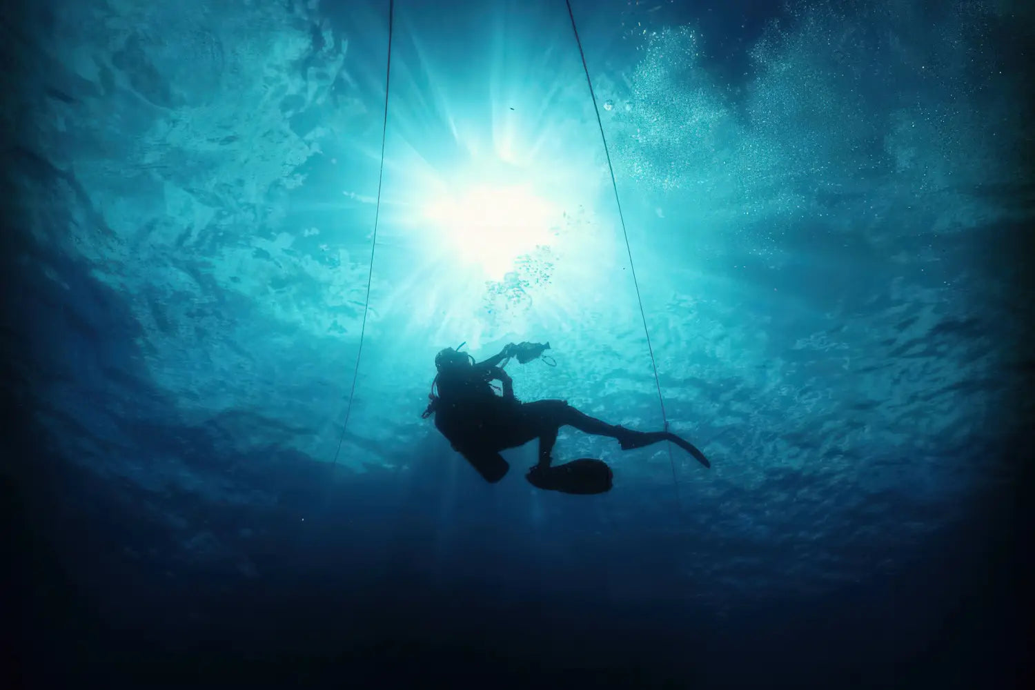 Diver underwater with sunlight filtering through water surface