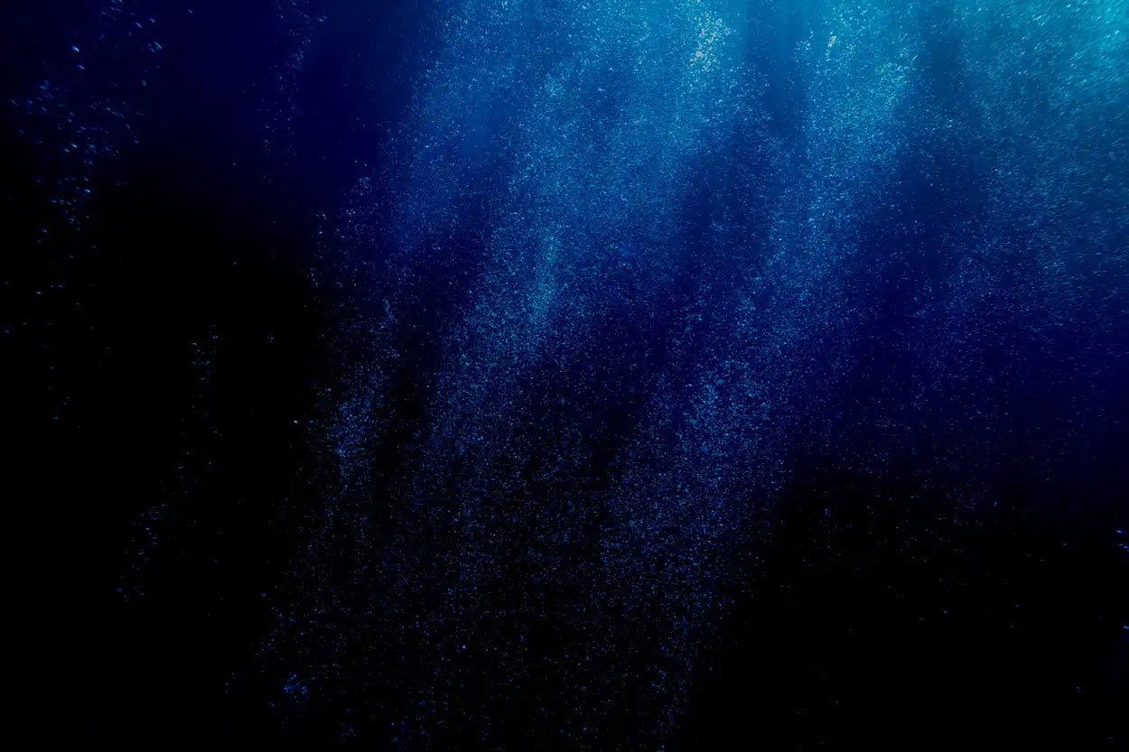 Dark blue underwater scene with light filtering through water