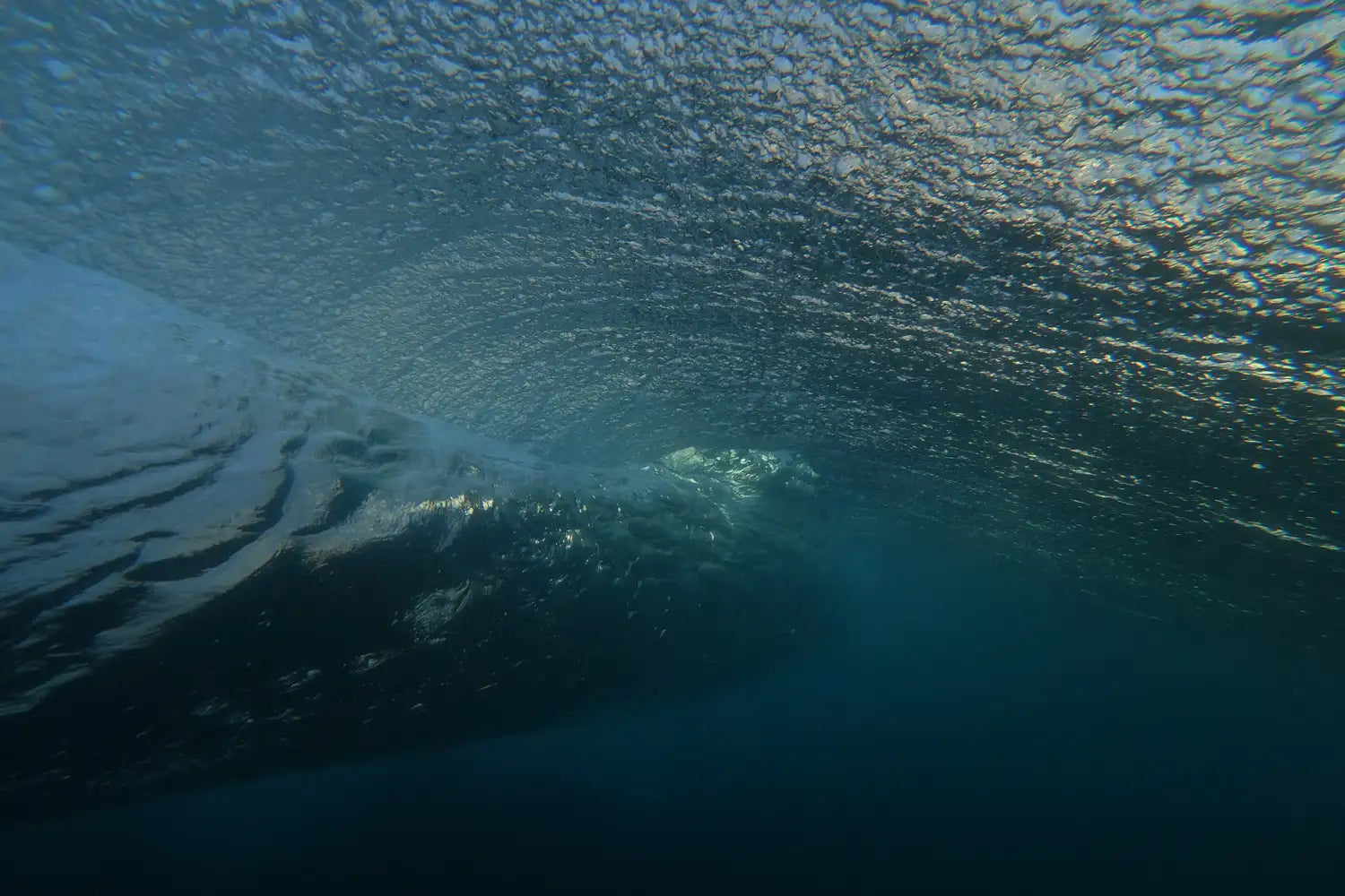 Close-up of a wave with sunlight filtering through the water.