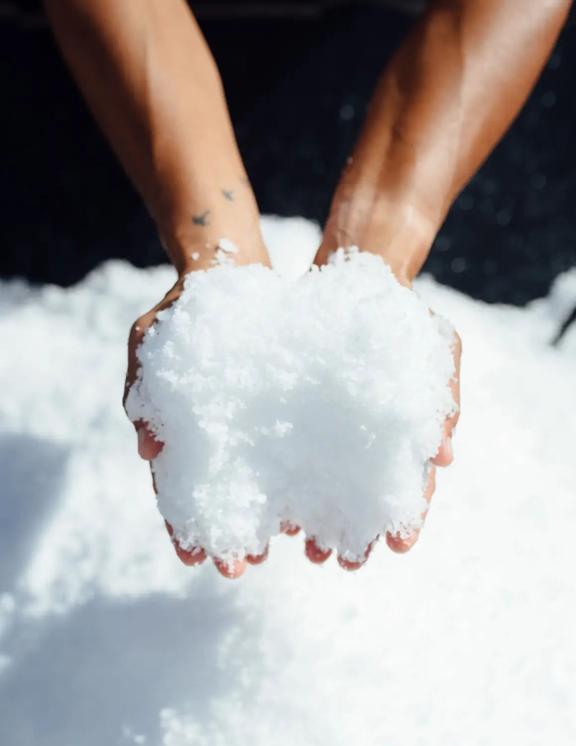 Close-up of hands holding a small pile of Kona Sea Salt